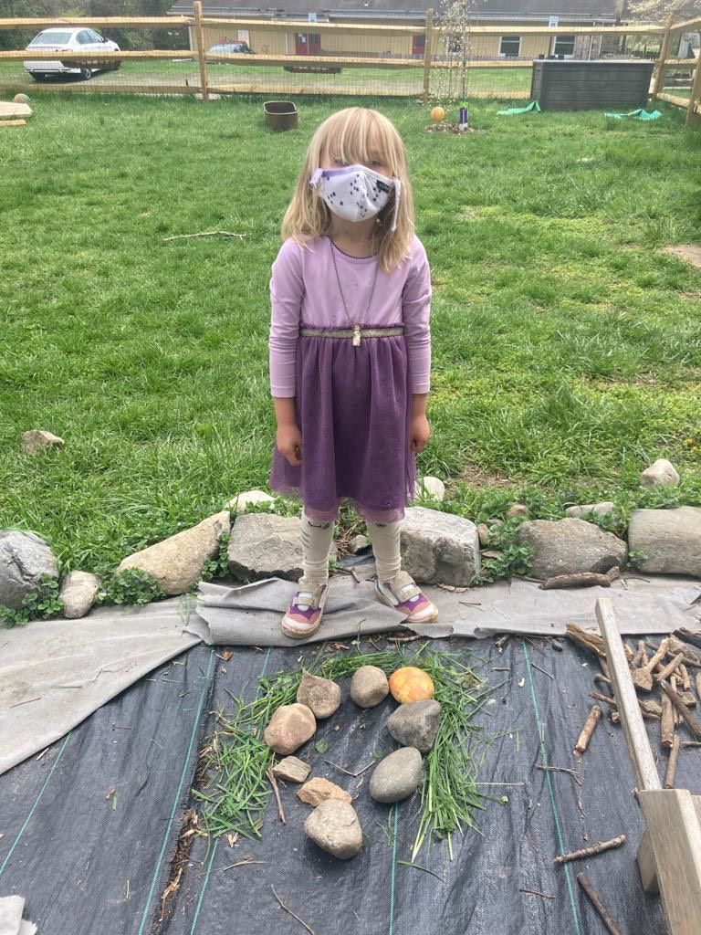 A child in our West Chester campus uses her imaginative skills to create a face using rocks, sticks and grass.